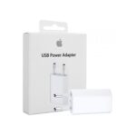 En vit USB-strömadapter med två runda stift visas framför sin förpackningslåda, som visar Apple-logotypen och texten "USB Power Adapter".